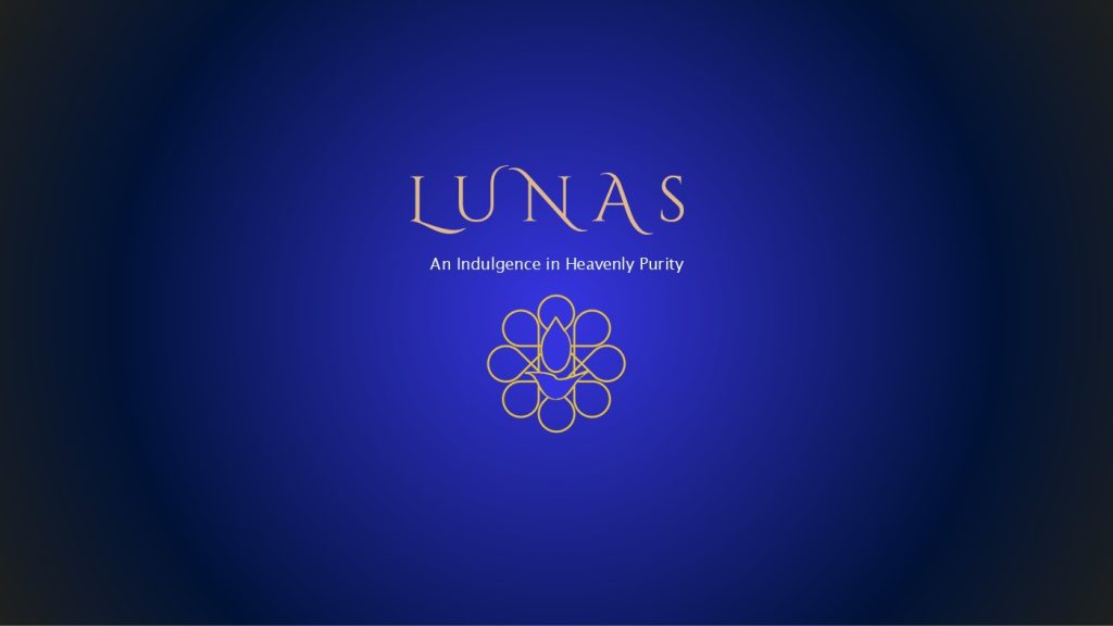 A deep royal blue cover slide with a soft radial glow at the centre, fading to near-black at the corners. The word "LUNAS" appears in an elegant gold serif script, centred in the upper-middle portion of the image. Below it, in a smaller white sans-serif font, reads the tagline "An Indulgence in Heavenly Purity." Beneath that sits the LUNAS logo, a symmetrical gold line-art design made up of overlapping circular and teardrop shapes arranged in a flower-like pattern.